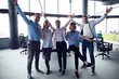 © opolja - Portrait of creative business team standing together and laughing. Multiracial business people together at startup.