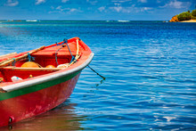 Small Wooden Colorful Boat On Clear Water Ocean