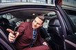 © qunica.com - Smiling businessman sitting in a limo