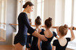 © Seventyfour - Back view portrait of elegant ballet teacher instructing group of little girl in dance studio, copy space