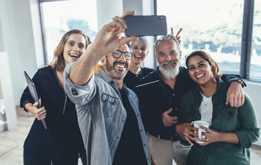 Cheerful people in the office taking selfie