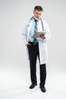 © opolja - full body picture of a mature doctor holding a notepad, on white background.