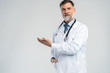© opolja - Doctor senior man, medical professional holding something in empty hand isolated over white background.