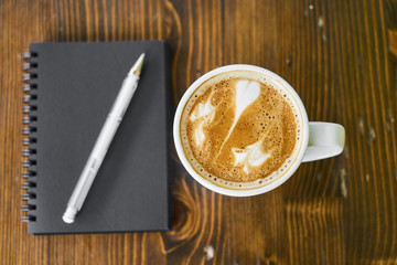 Cup of hot coffee latte on a wooden table