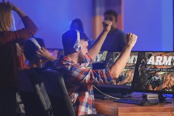 Wall Mural - Young people playing video games at tournament