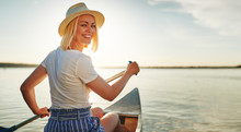 Smiling Young Woman Canoeing On A Lake In Summer