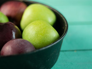 Wall Mural - Apples in an vintage iron plate on a wooden background. Side view