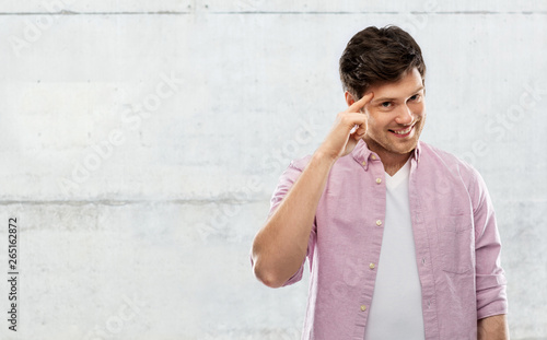 Cuadros en Lienzo idea, intelligence and imagination concept - smiling young man pointing finger t