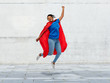 super power and people concept - happy african american young woman in superhero red cape over grey concrete background