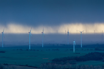 Dark clouds and heavy rain passing through a wind farm