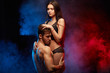 Amazing young sexy couple is hugging before sepparation.isolated black smoky background