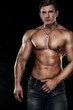 © Mike Orlov - Bodybuilding competitions on the scene. Man sportsmen physique and athlete. Black background with lights.