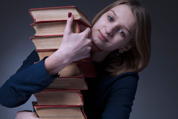 Treasure of knowledge books concept. Portrait of happy young woman with the books. Horizontal image.