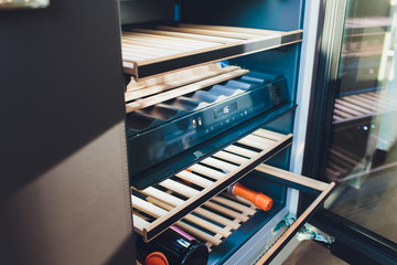 Storing bottles of wine in fridge. Alcoholic card in restaurant. Cooling and preserving wine.