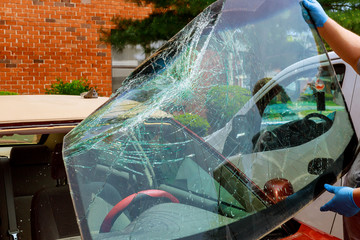 Broken windshield car special workers take of windshield of a car in auto service