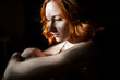 © Cavan Images - Pensive redhead woman sitting