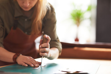 Wall Mural - Closeup of unrecognizable female artisan making leather bag in workshop, copy space