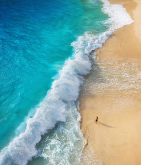Wall Mural - view of a man on the beach on bali, indonesia. vacation and adventure. top view from drone at beach,