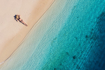 Wall Mural - aerial view of a girl on the beach on bali, indonesia. vacation and adventure. beach and turquoise w