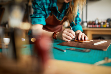 Wall Mural - Warm toned portrait of unrecognizable artisan making leather bag in atelier, copy space