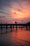Fototapeta  - ouple silhouette standing on jetty in sunset twilight
