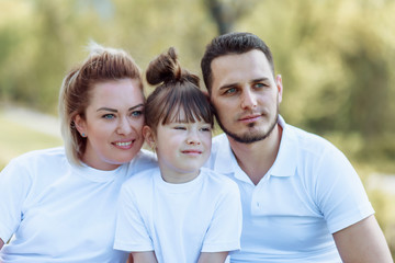 Young happy family of three having fun together outdoor.