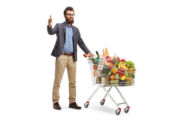 Wall Mural - Male customer with a shopping cart giving thumbs up