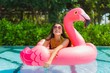 © siraphol - Portrait beautiful young asian woman on the flamingo inflatable float in swimming pool at hotel resort