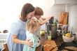 © natalialeb - Cute mom and small children with juicer squeeze