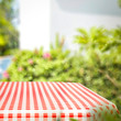 © magdal3na - Tablecloth of red and white color and summer background of garden. Free space for your decoration.