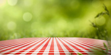 White And Red Tablecloth And Free Space For Your Decoration. Summer Blurred Background Of Grass And Sun Light. 