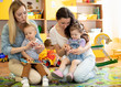© Oksana Kuzmina - Babies toddlers playing with colorful educational toys together with mothers in nursery room