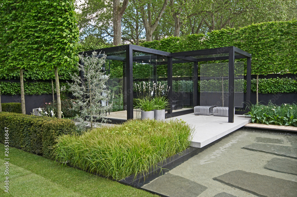 A cool modern garden with some Scandinavian style and a water feature - obrazy, fototapety, plakaty 