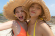 Beautiful young women have summer holiday or vacation time at beautiful beach. Pretty girls get enjoying their summer season life together. Asian women get happiness and fun. They wear bikini, hats.