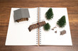 Two miniatures camping with Pine tree, Bridge and House on white blank notebook