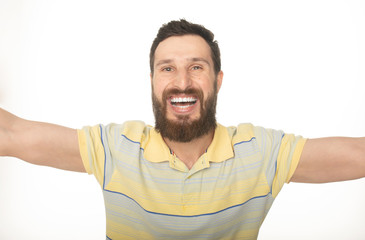 Close up portrait of a cheerful bearded man taking selfie over white background 