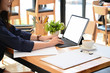 © Prathankarnpap - Women working with mockup tablet on table in office co working.