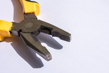 Pliers with yellow handle on white background