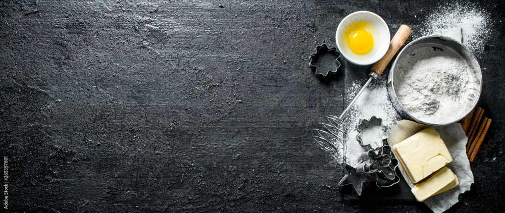 Baking background. Flour with egg, butter and various forms for baking. - obrazy, fototapety, plakaty 