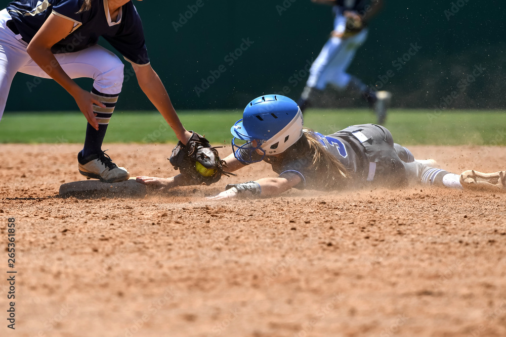 Young high school softball players in action, making amazing plays, during a game - obrazy, fototapety, plakaty 
