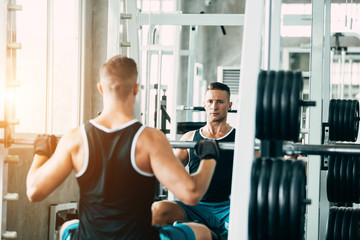 portrait of sporty girl workout on exercise machine in gym. Pretty young man training in the gym