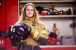 © Sergey Mironov - Photo of woman firefighter with helmet in her hands standing near fire truck
