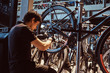 © Fxquadro - Young attractive mechanic is fixing customer's bicycle at his own workshop.