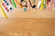 © photoguns - Top border frame made of stationery, school supplies on wooden table. Education, studying and back to school concept. Child desk top view, copy space, flat lay composition.