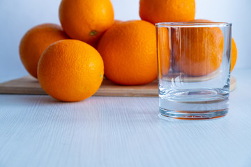 Wall Mural - Empty wine glass is on the table next to the oranges.