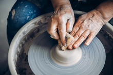 Wrinkled Hands Wizard On Potter Wheel Makes Clay Dishes. Place To Work. Top View
