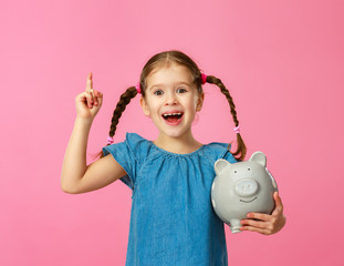 Wall Mural - financial concept of children's pocket money. child girl with piggy Bank      on a colored pink background