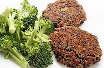 Homemade black bean burgers with a side of fresh organic broccoli