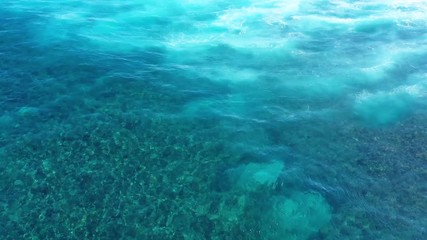 Wall Mural - waves and azure water as a background. view from high rock at the ocean surface. natural summer seas