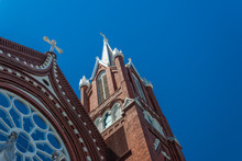 Beautiful Details Of Steeples And Rose Window, Gothic Revival Church, Red Brick White Crosses, Blue Sky, Horizontal Aspect